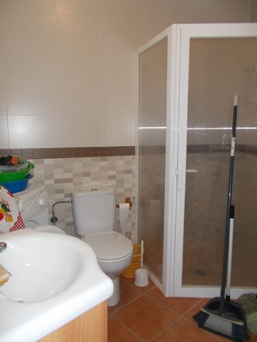 Bathroom with toilet, sink, and shower in a cave house in Bacor, Granada.