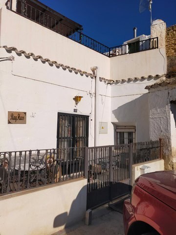 Cave house in Benamaurel, Granada with white exterior walls and a small outdoor terrace.