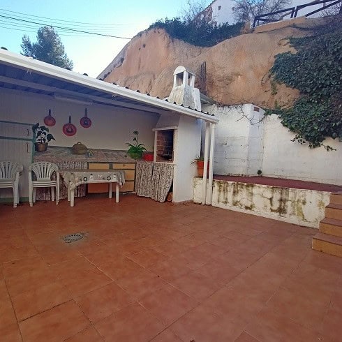 Charming outdoor patio of a village property in Fontanar, Jaen, featuring terracotta tiles, a built-.