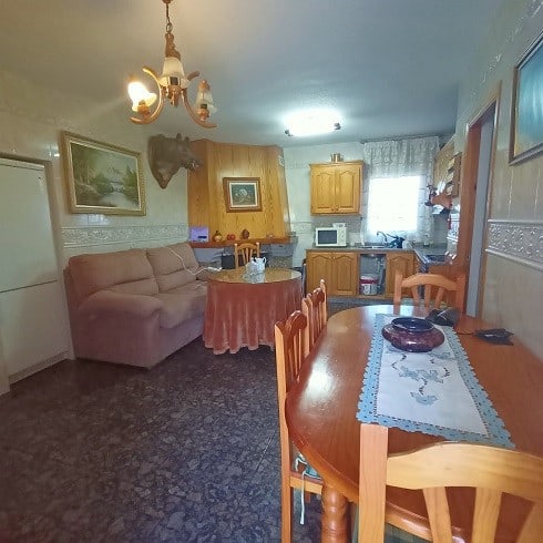 Interior view of a village property in Fontanar, Jaen, featuring a living room and kitchen area.