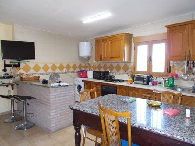Cozy rural property kitchen in Seron, Almeria with wooden cabinets, granite countertop, and modern a.