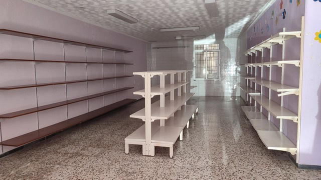 Retail space with multiple empty shelves in a well-lit store.