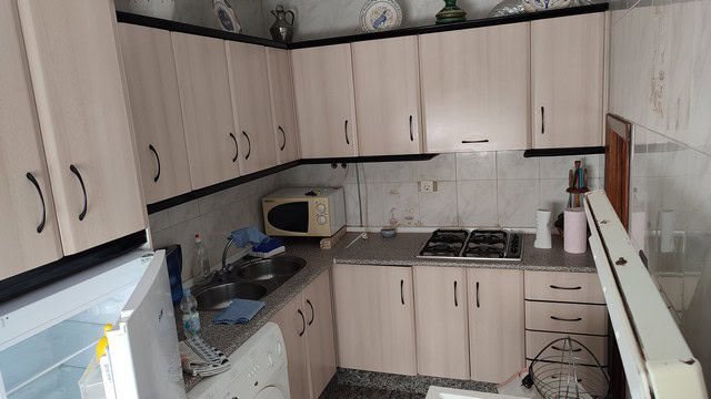 Charming town house interior in Caniles, Granada, featuring a compact kitchen with cabinets, stove,.