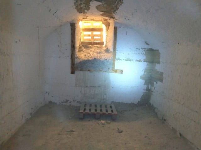 Cave house interior with small window in Benamaurel, Granada, showcasing rustic stone walls and natu.