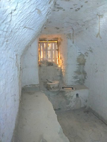 Cave house interior with rustic stone walls and small window in Benamaurel, Granada. Unique traditio.