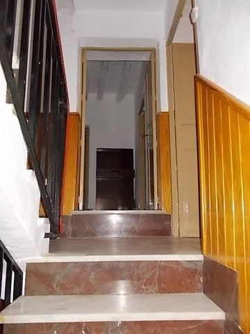 Charming village property entrance in Somontin, Almeria, featuring stairs and wooden accents.