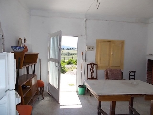 Rural property interior with open door leading to scenic countryside in Tijola, Almeria.