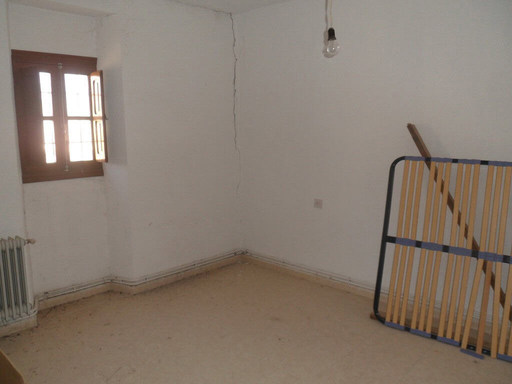 Interior of a village property in Campo Camara, Granada, showing a simple room with a window and min.