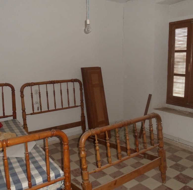 Charming bedroom with vintage wooden beds in a rural village home in Campo Camara, Granada.