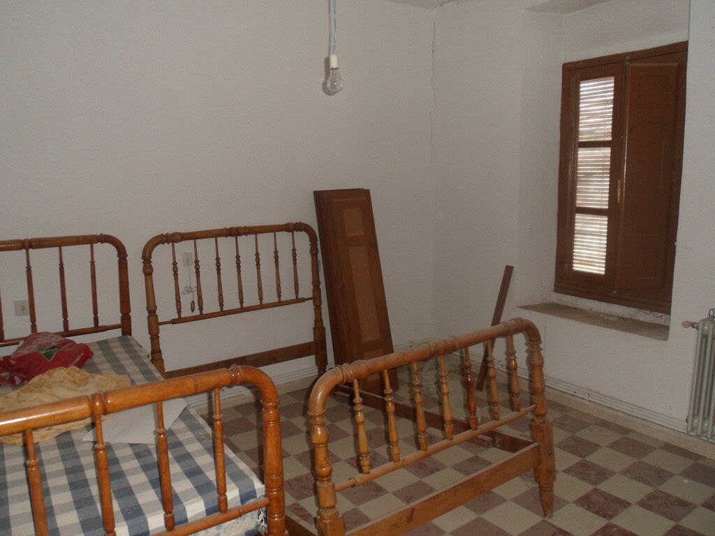 Charming bedroom with vintage wooden beds in a rural village home in Campo Camara, Granada.