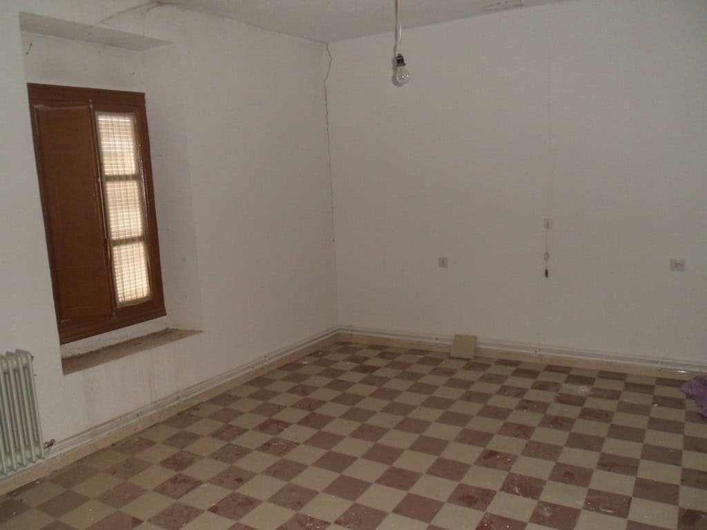 Interior view of a village property in Campo Camara, Granada, showing an empty room with a window an.