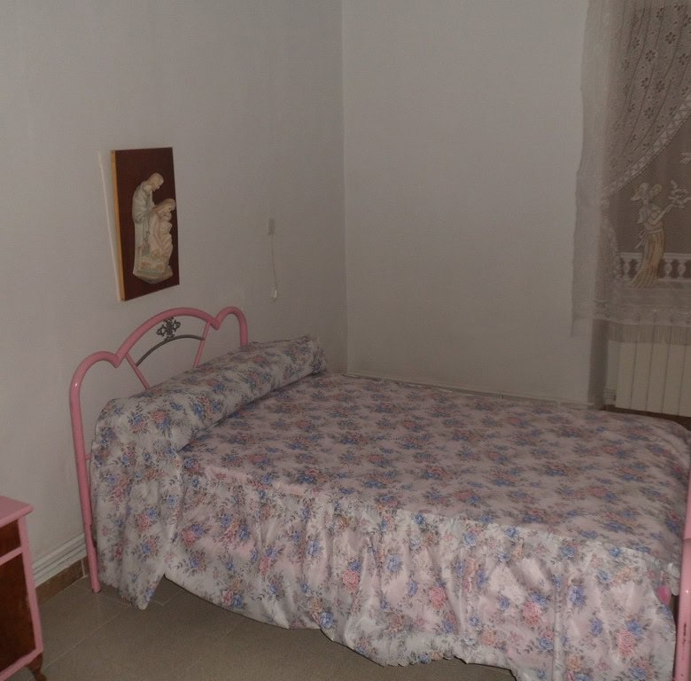 Charming bedroom in a village property located in Campo Camara, Granada, featuring a pink metal bed.