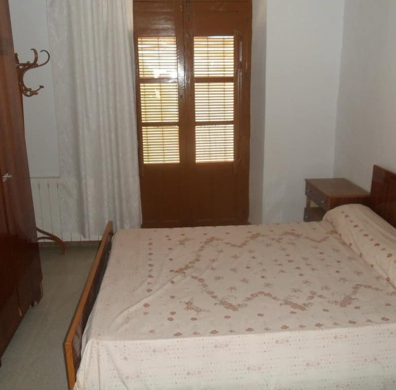 Charming bedroom in a village property in Campo Camara, Granada, featuring wooden furniture and natu.