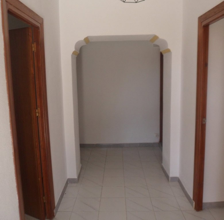 Village property entrance in Campo Camara, Granada with white walls and wooden door frames.