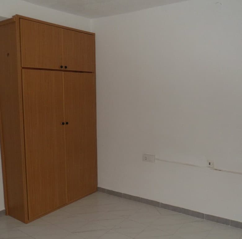 Interior view of a village property in Campo Camara, Granada, featuring a wooden wardrobe and simple.
