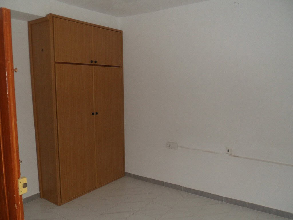 Interior view of a village property in Campo Camara, Granada, featuring a wooden wardrobe and simple.