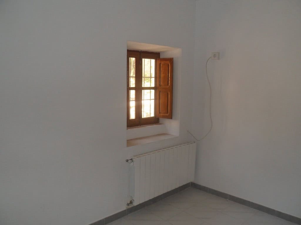 Cozy interior with wooden window in a rural village property in Campo Camara, Granada.