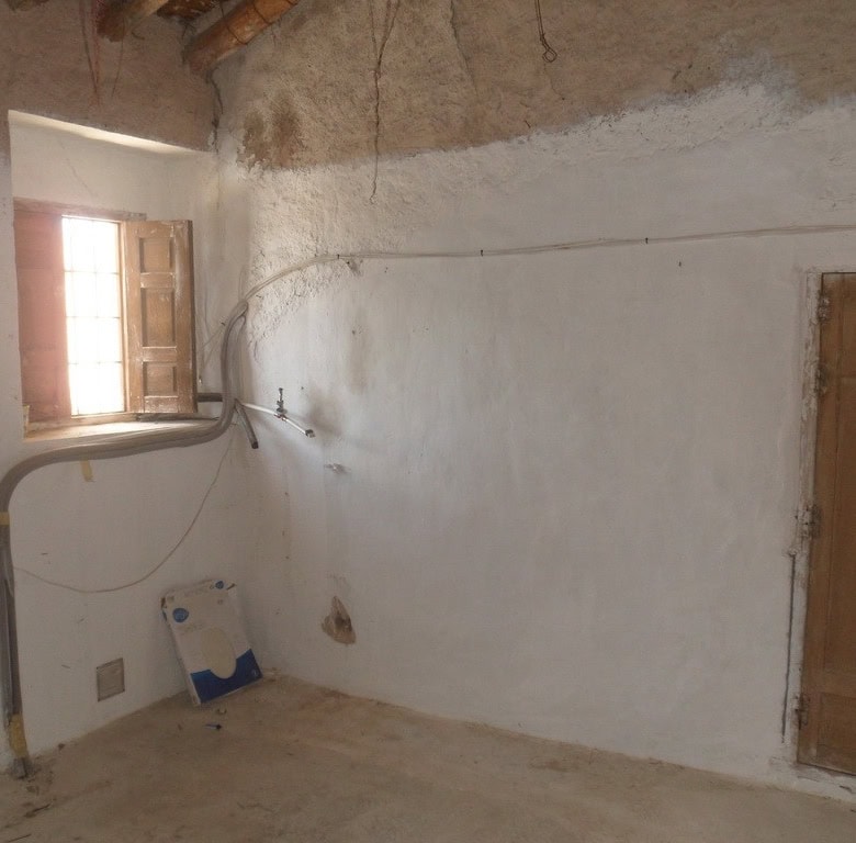 Village property interior with rustic walls and a small window in Campo Camara, Granada.