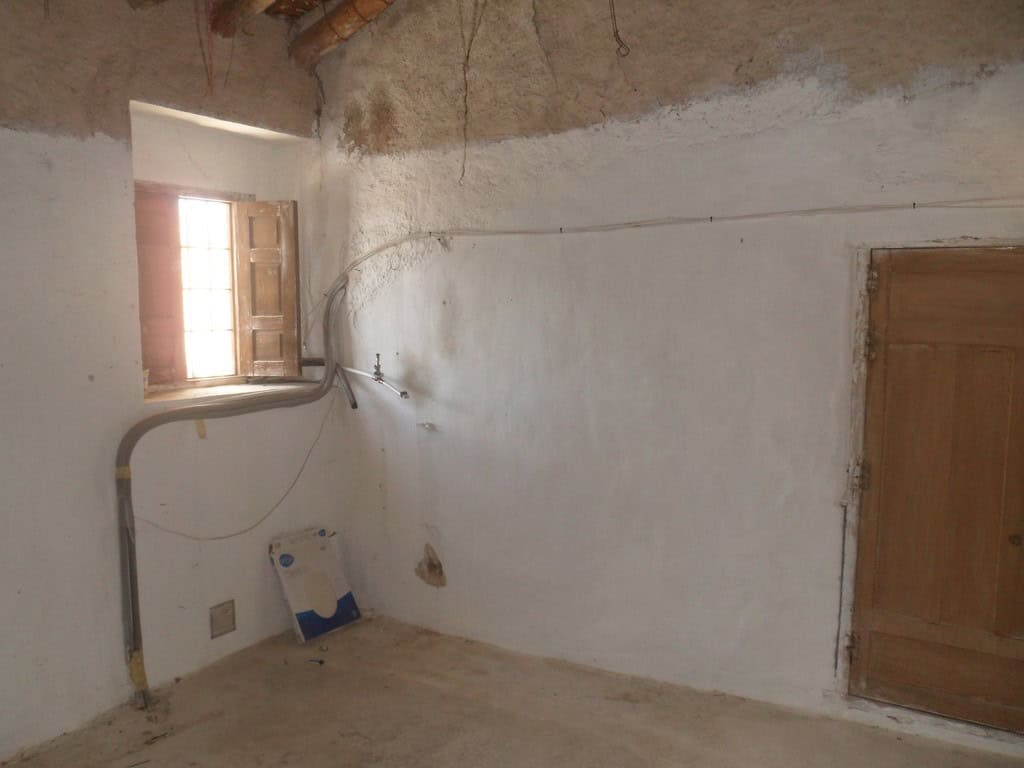 Village property interior with rustic walls and a small window in Campo Camara, Granada.