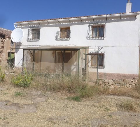Chirivel rural property with traditional white exterior, garden area, and mountain views in Almeria.