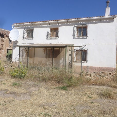 Chirivel rural property with traditional white exterior, garden area, and mountain views in Almeria.