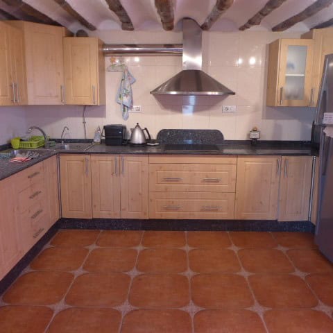 Cozy rural kitchen in Chirivel, Almeria with wooden cabinets and modern appliances.