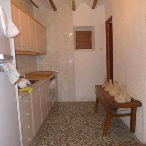 Chirivel village property features a simple kitchen with wooden cabinets and traditional decor.