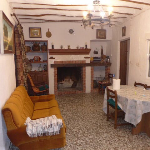 Charming village house interior in Chirivel, Almeria, featuring a cozy living room with a fireplace,.