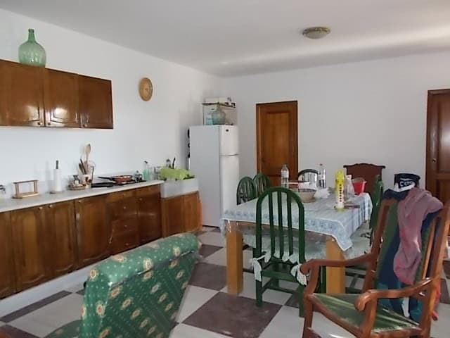 Rural property kitchen with wooden cabinets, dining table, and mixed seating in Purchena, Almeria.