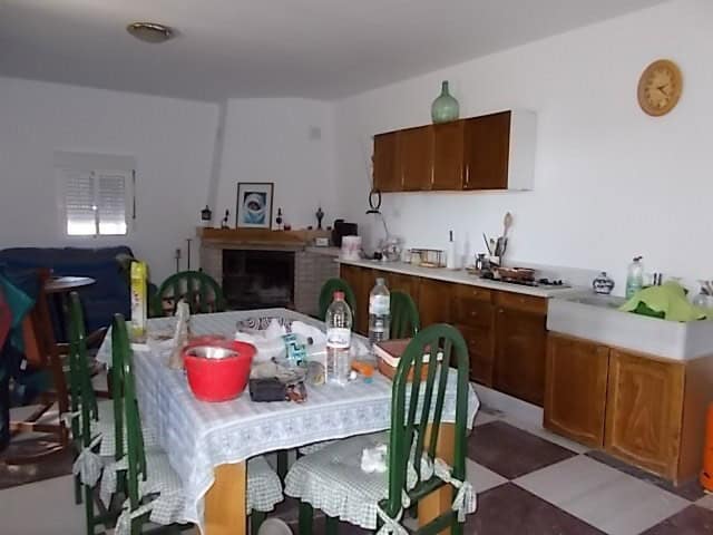 Rural property kitchen in Purchena, Almeria with wooden cabinets and a cozy dining space.