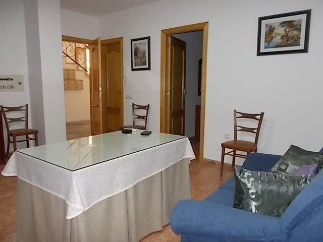 Cozy living room with dining area in Tijola, Almeria, featuring simple decor and wooden furniture.