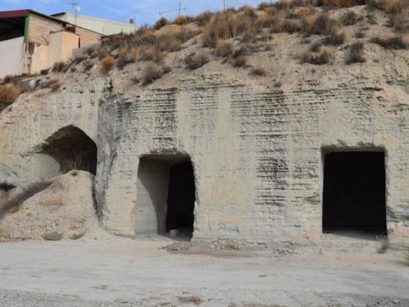 Cave house with three dark entrances built into a hillside in Benamaurel, Granada. Rustic and unique.