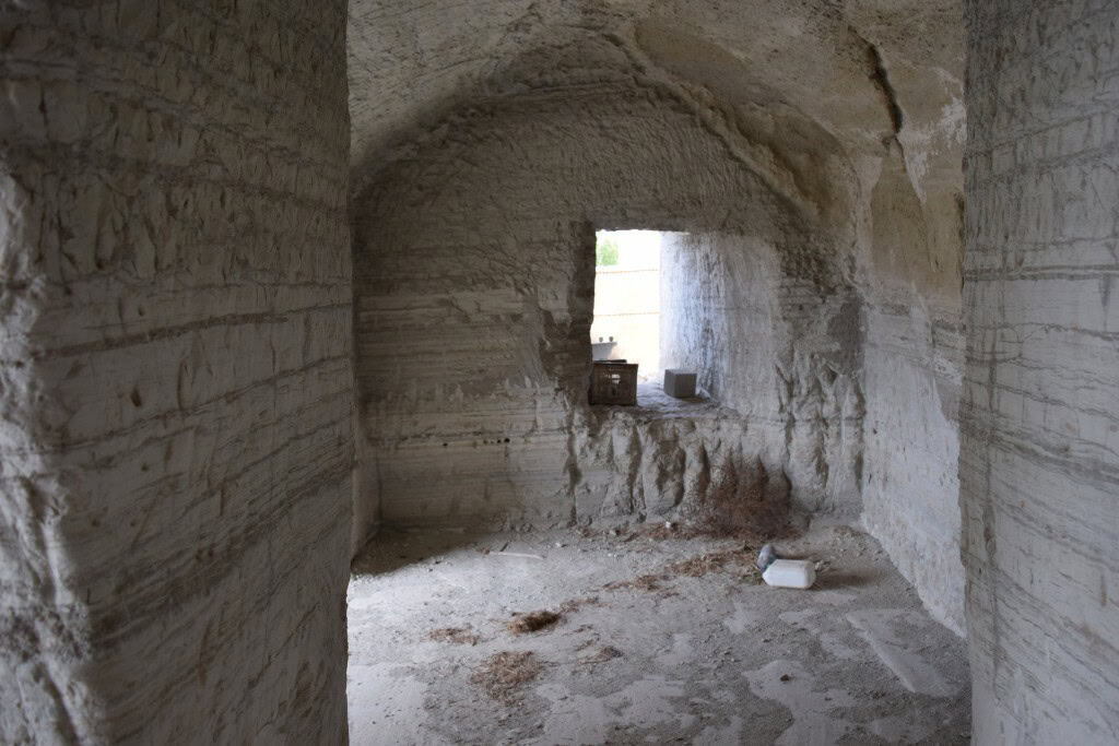 Ancient cave house interior in Benamaurel, Granada, showcasing natural stone walls and rustic charm.