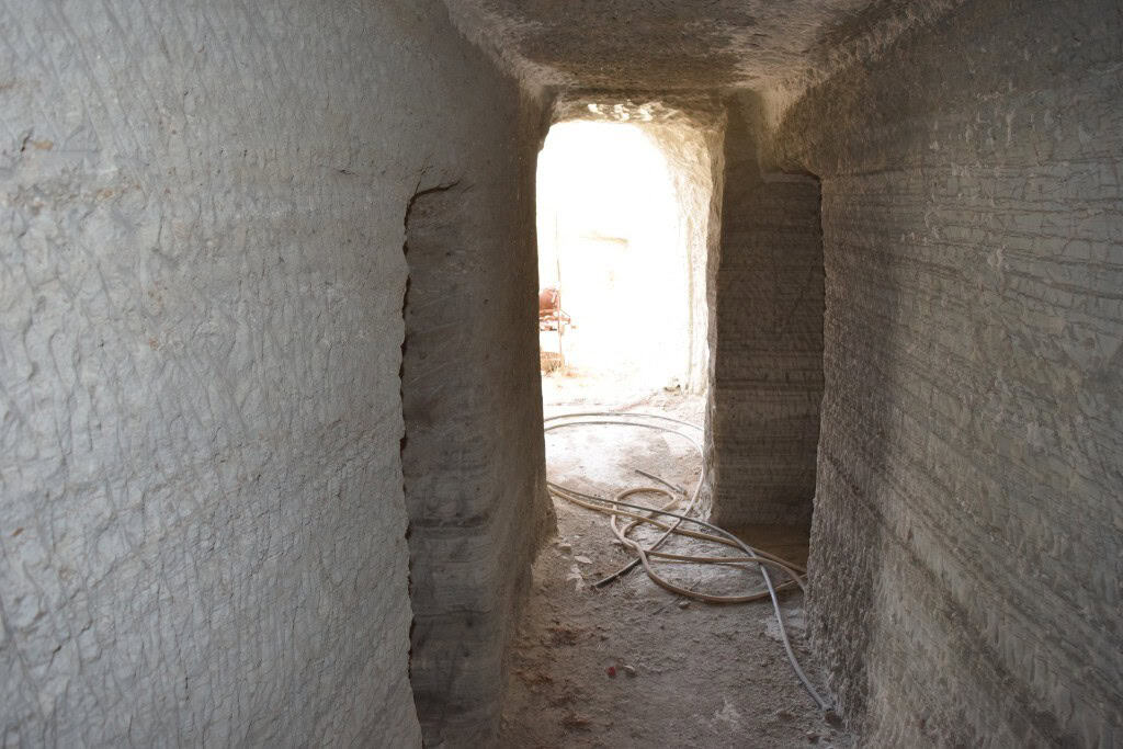 Cave house interior under construction in Benamaurel, Granada, with exposed stone walls and construc.