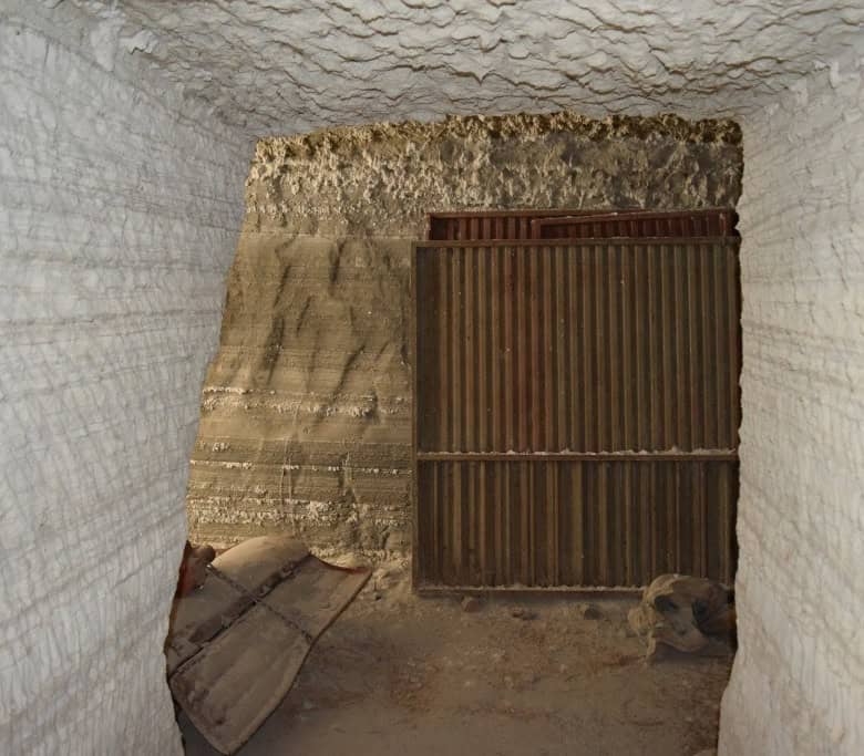 Cave house entrance with wooden gate in Benamaurel, Granada, showcasing traditional cave dwelling ar.