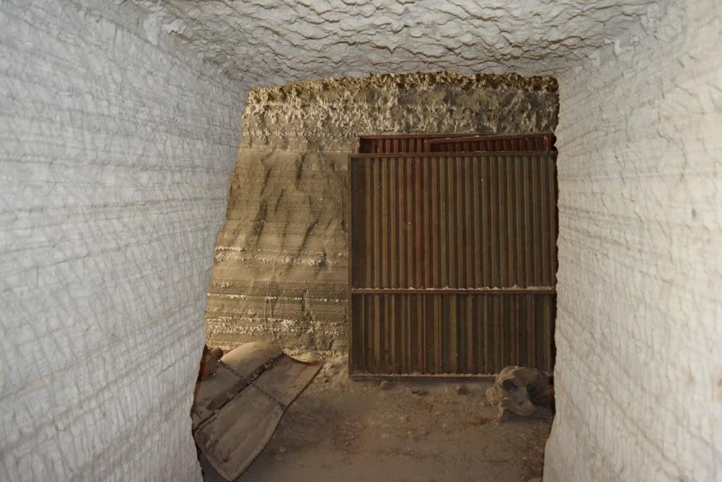 Cave house entrance with wooden gate in Benamaurel, Granada, showcasing traditional cave dwelling ar.