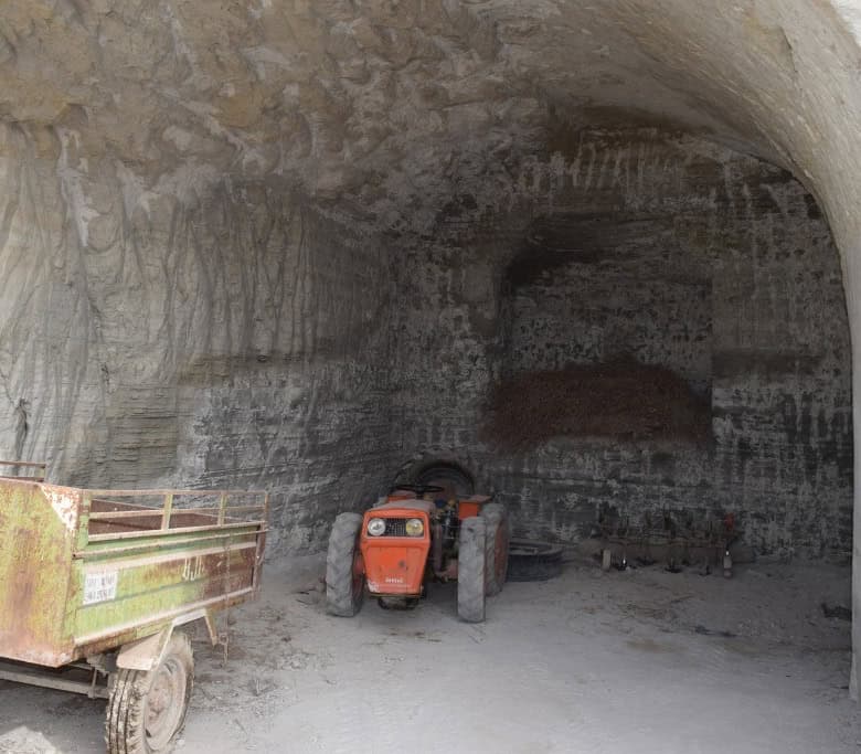 Cave house entrance in Benamaurel, Granada, with a tractor parked inside the cave.