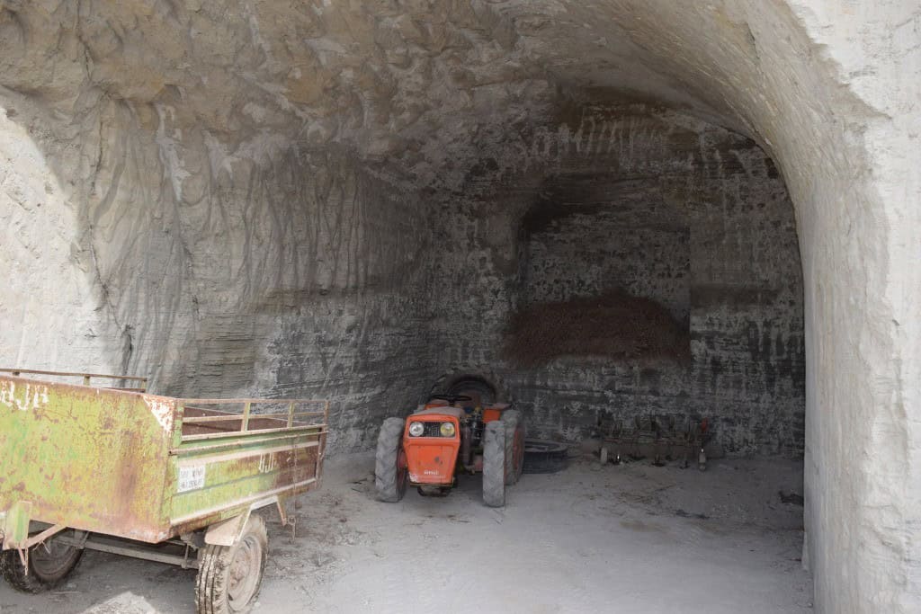 Cave house entrance in Benamaurel, Granada, with a tractor parked inside the cave.