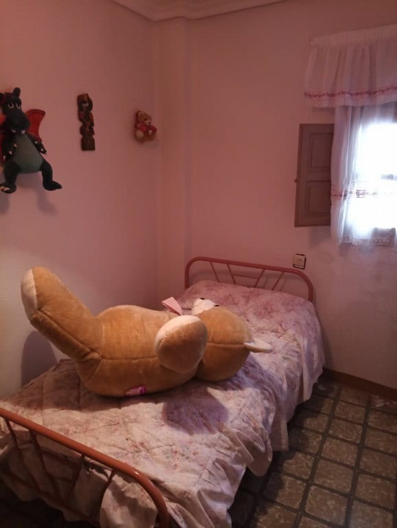 Charming bedroom in a town house in Baza, Granada, featuring a single bed with plush teddy bear, dec.
