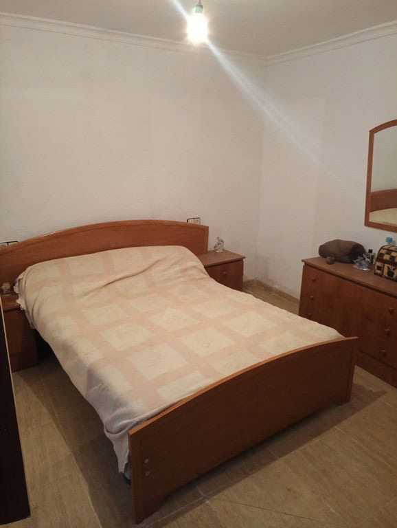 Cozy bedroom in a traditional town house located in Baza, Granada, featuring wooden furniture and si.