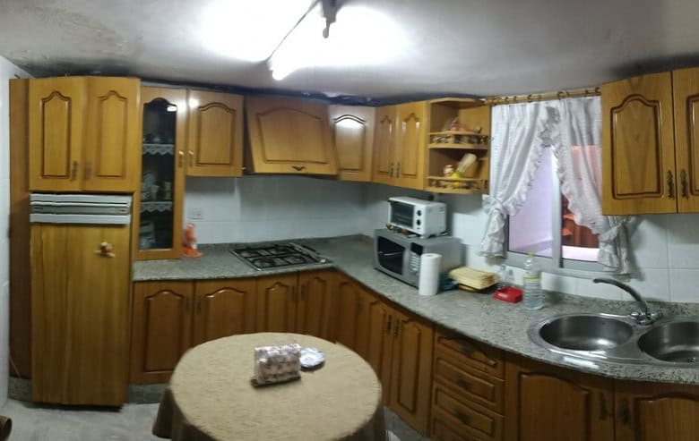 Cozy kitchen in a town house located in Baza, Granada, featuring wooden cabinets, a microwave, and a.