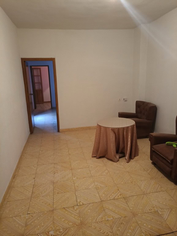 Charming interior of a town house in Baza, Granada, featuring simple furnishings and tiled flooring.