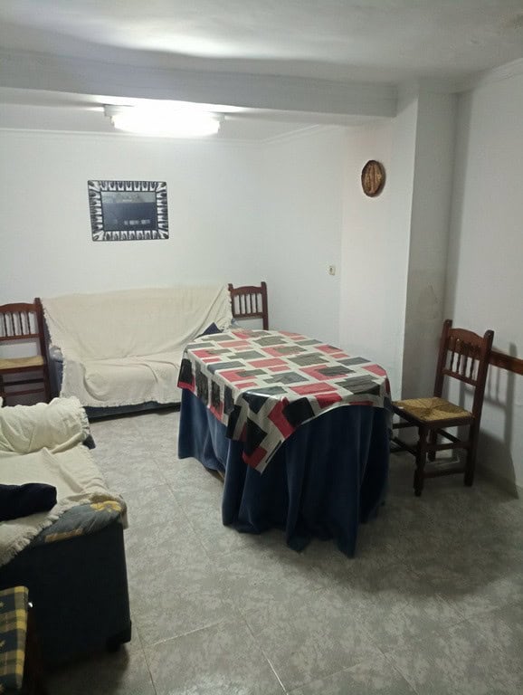 Cozy interior of a town house in Baza, Granada, featuring a dining area and simple furnishings.