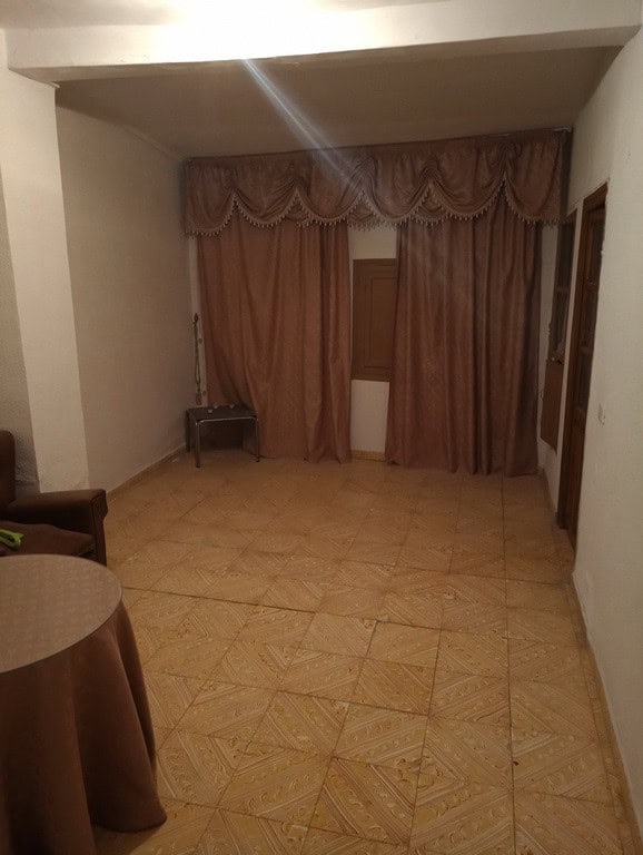 Living room with large window and curtains in Baza, Granada.