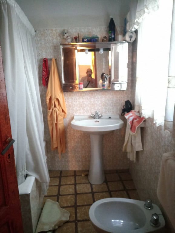 Cozy bathroom in a town house located in Baza, Granada, featuring a sink, mirror, and natural light.