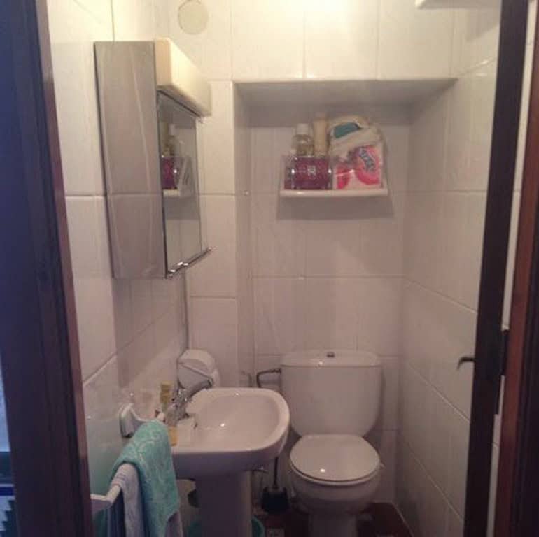 Charming bathroom in a town house located in Baza, Granada, featuring a compact sink, toilet, and st.