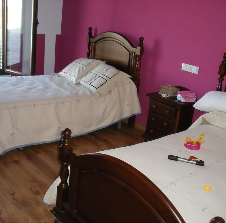 Cozy bedroom in a traditional cave house located in Benamaurel, Granada, featuring rustic wooden fur.
