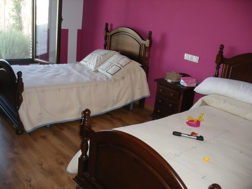 Cozy bedroom in a traditional cave house located in Benamaurel, Granada, featuring rustic wooden fur.