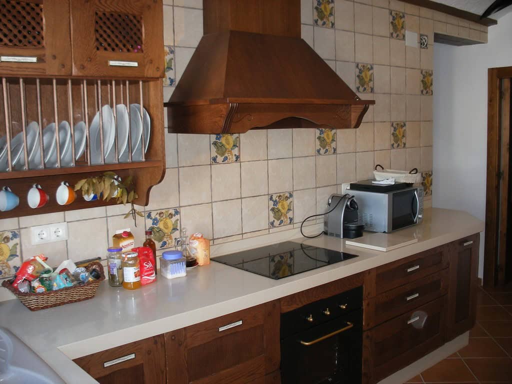 Cozy kitchen of a cave house in Benamaurel, Granada, featuring traditional wooden cabinets and moder.