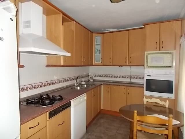 Cozy kitchen in a town house located in Tijola, Almeria, featuring wooden cabinets and modern applia.